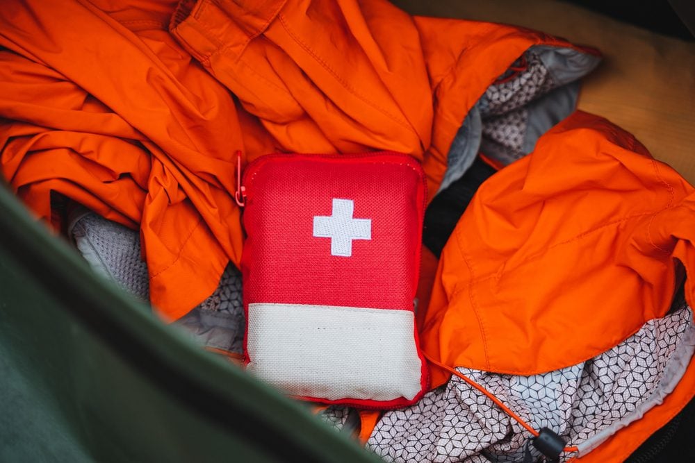 A red first aid kit with a white cross is shown from above