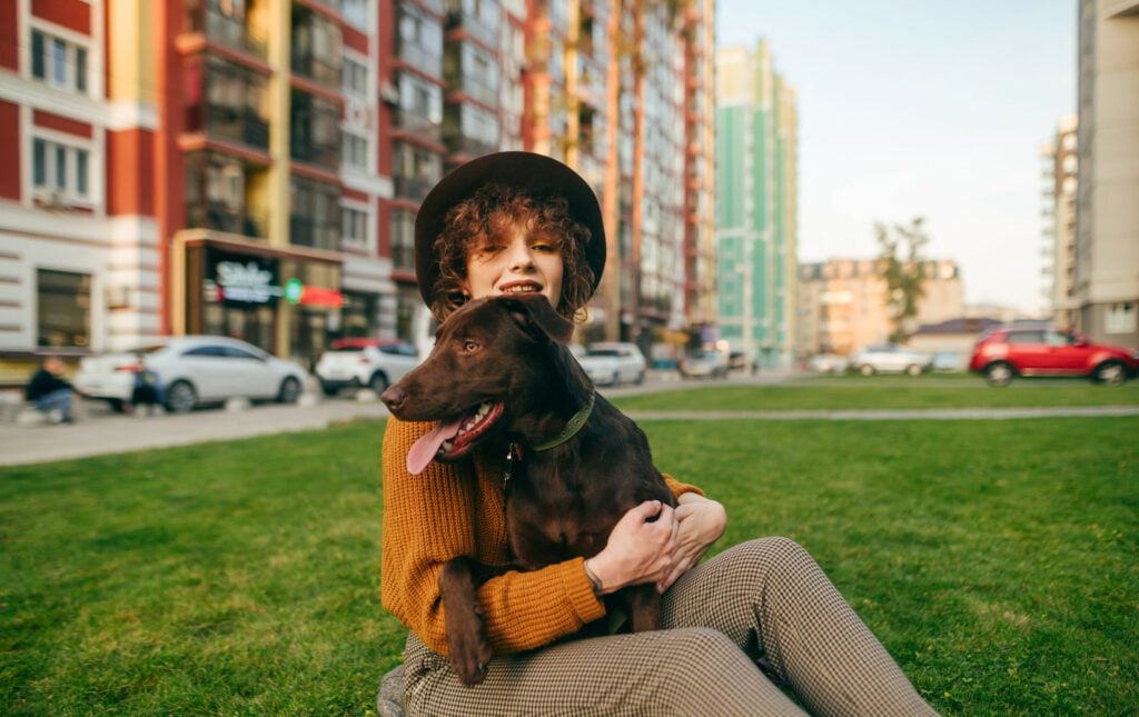 A person sits outside shops with their service dog for anxiety.