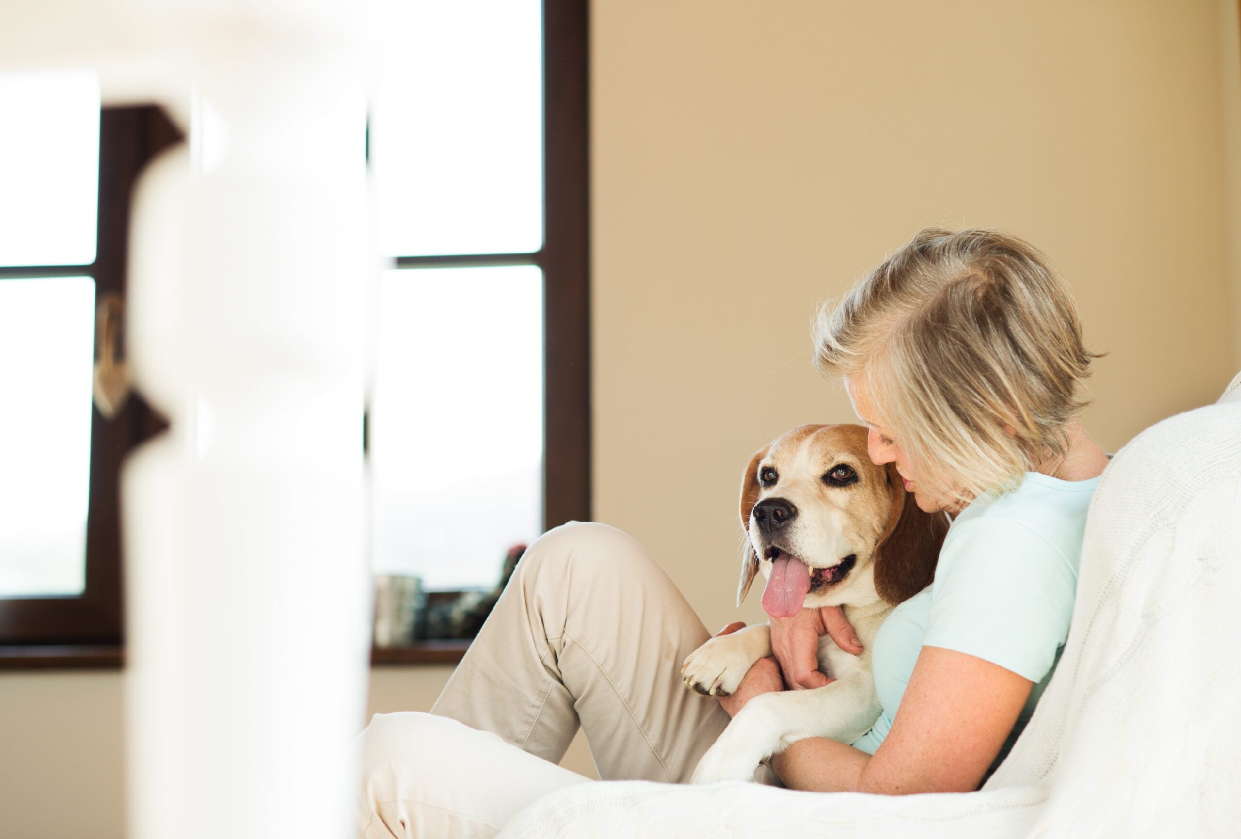 Woman cuddling her dog on the couch at home, a scene that reflects how Tennessee emotional support animal laws protect ESA owners.