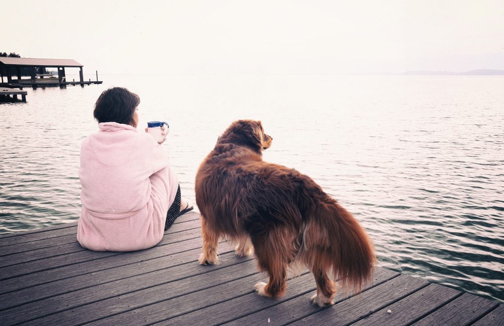 dog and woman by lake