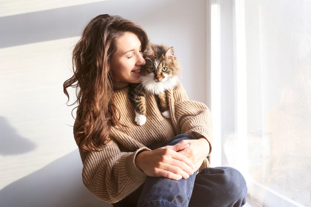 woman laughing holding siberian cat