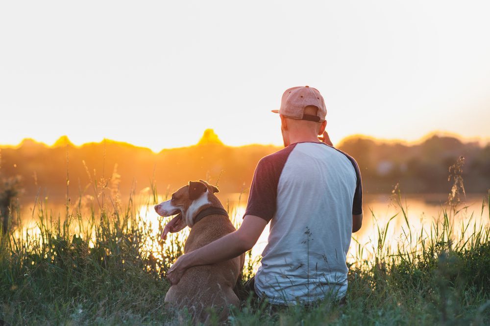A man and his emotional support dog sitting quietly by a lake in Birmingham, AL.