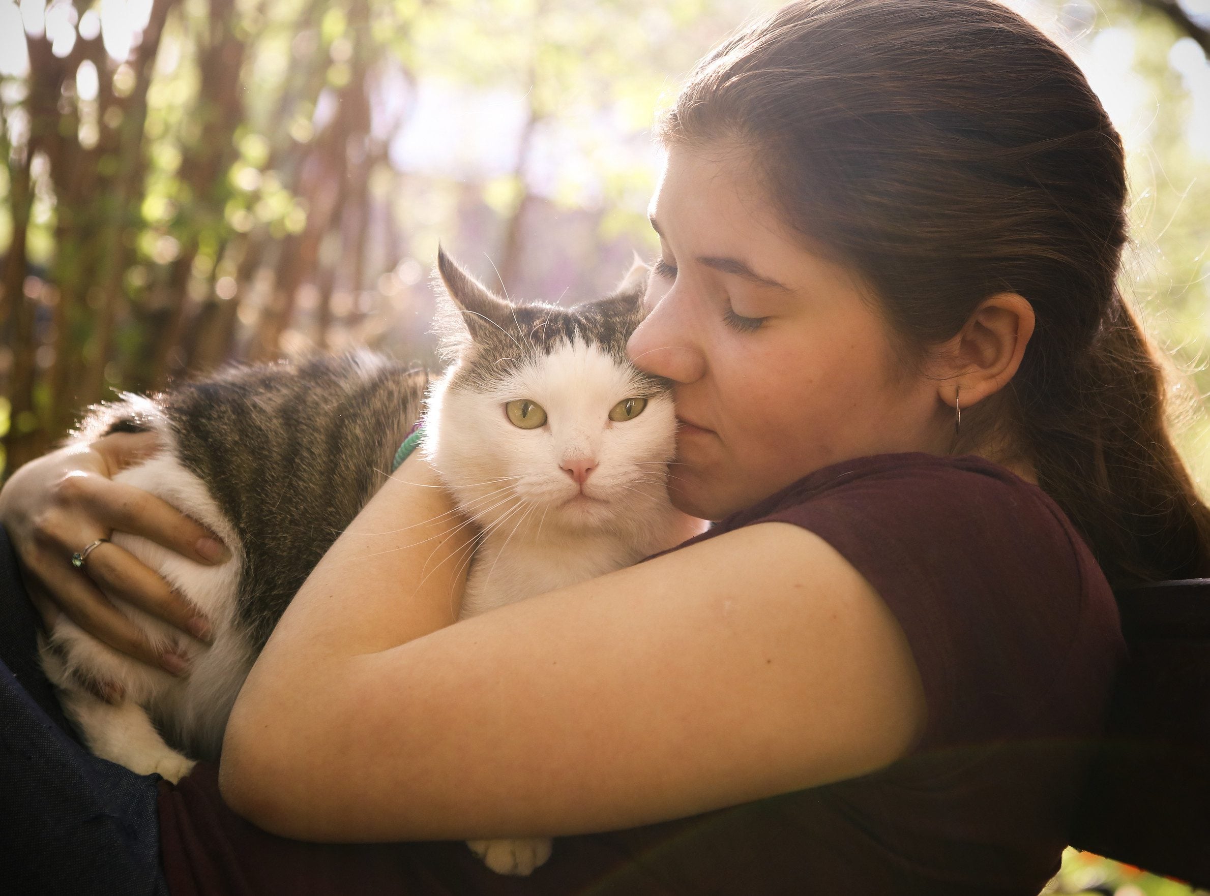 A young woman smiling while cuddling her emotional support animal in St. Paul.