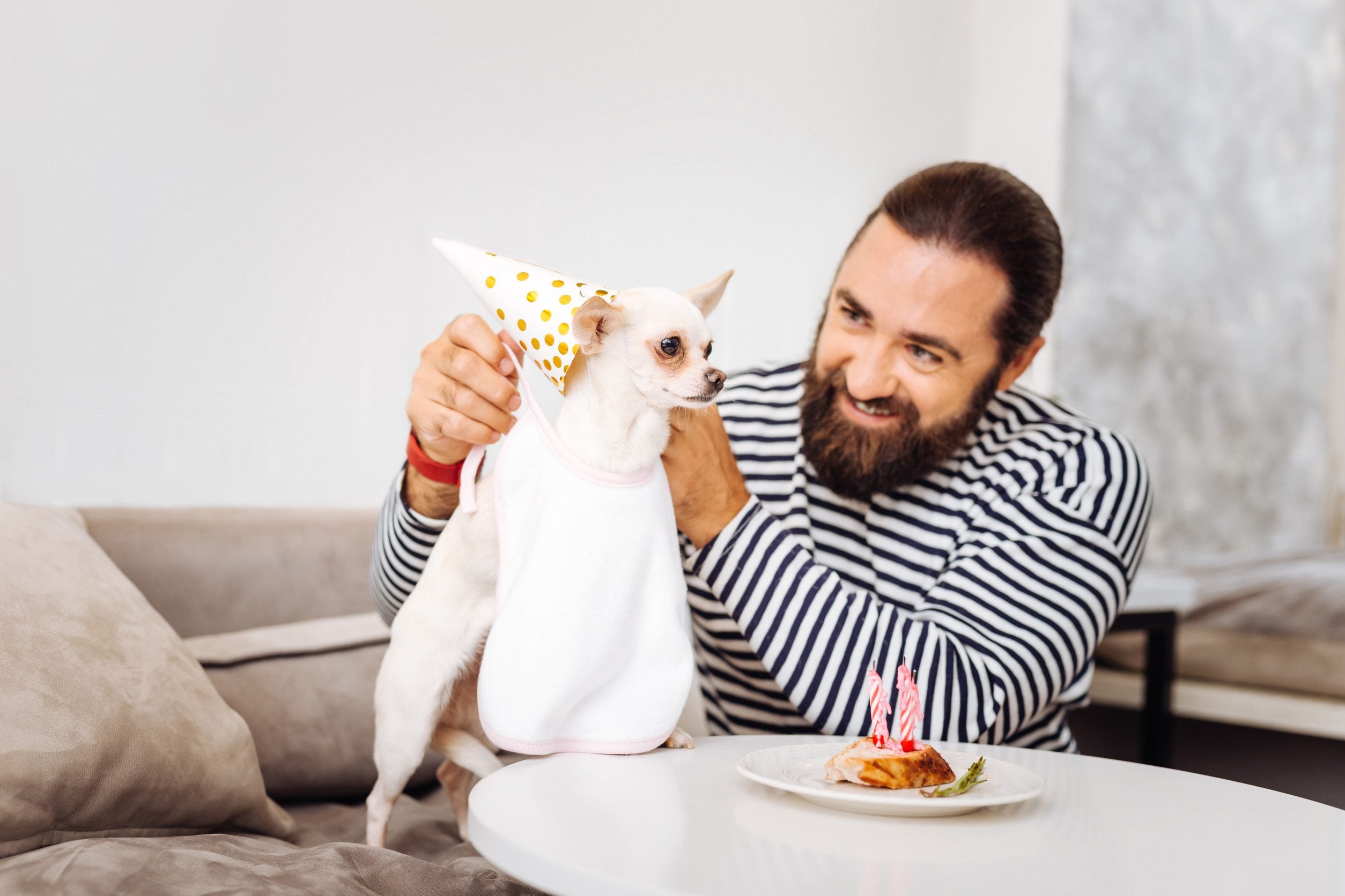 A man wearing a striped shirt celebrating his emotional support animal’s birthday in Southaven, MS.