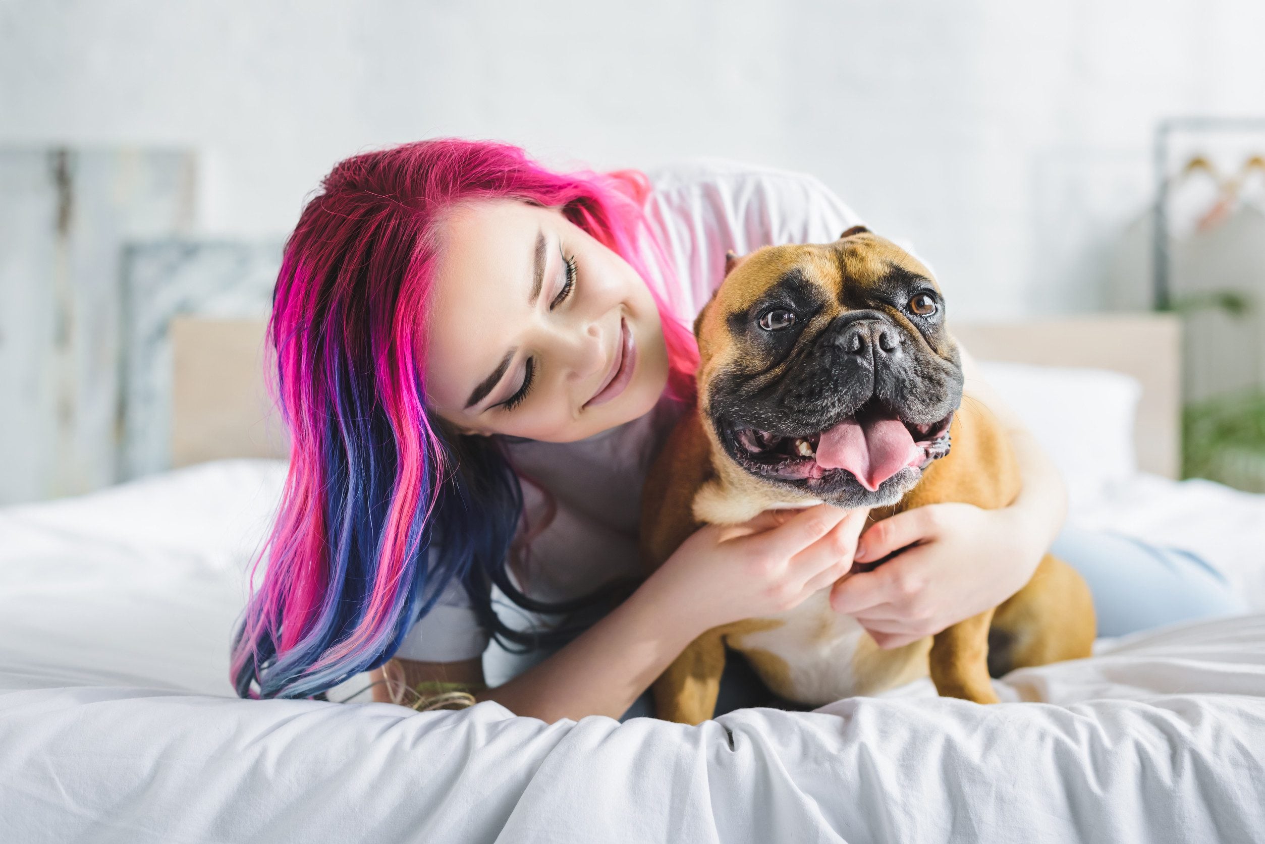 A woman lying in bed with her emotional support animal in St. Petersburg, FL.