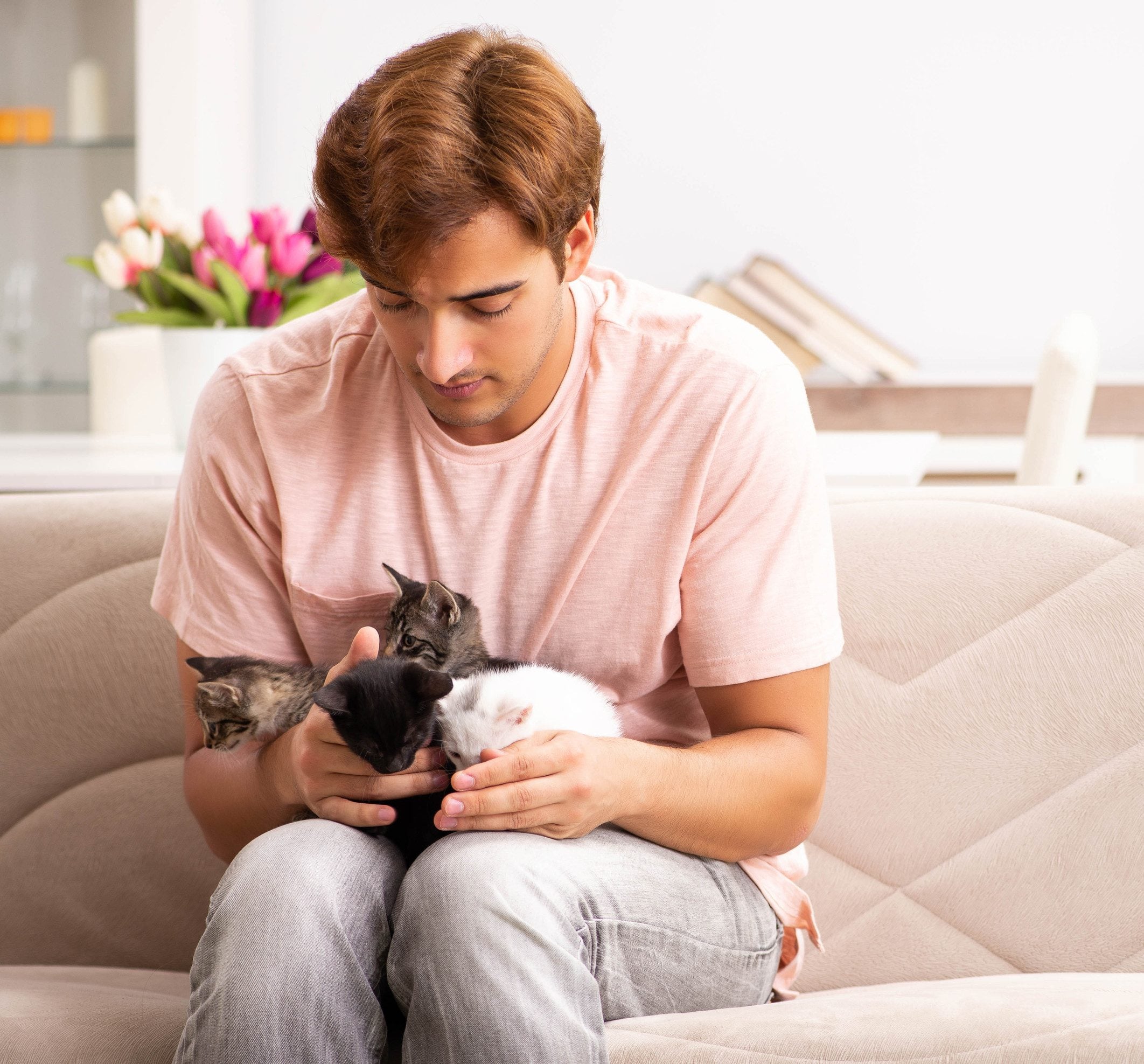A young man holding emotional support animals for warmth and comfort in Rochester, MN.