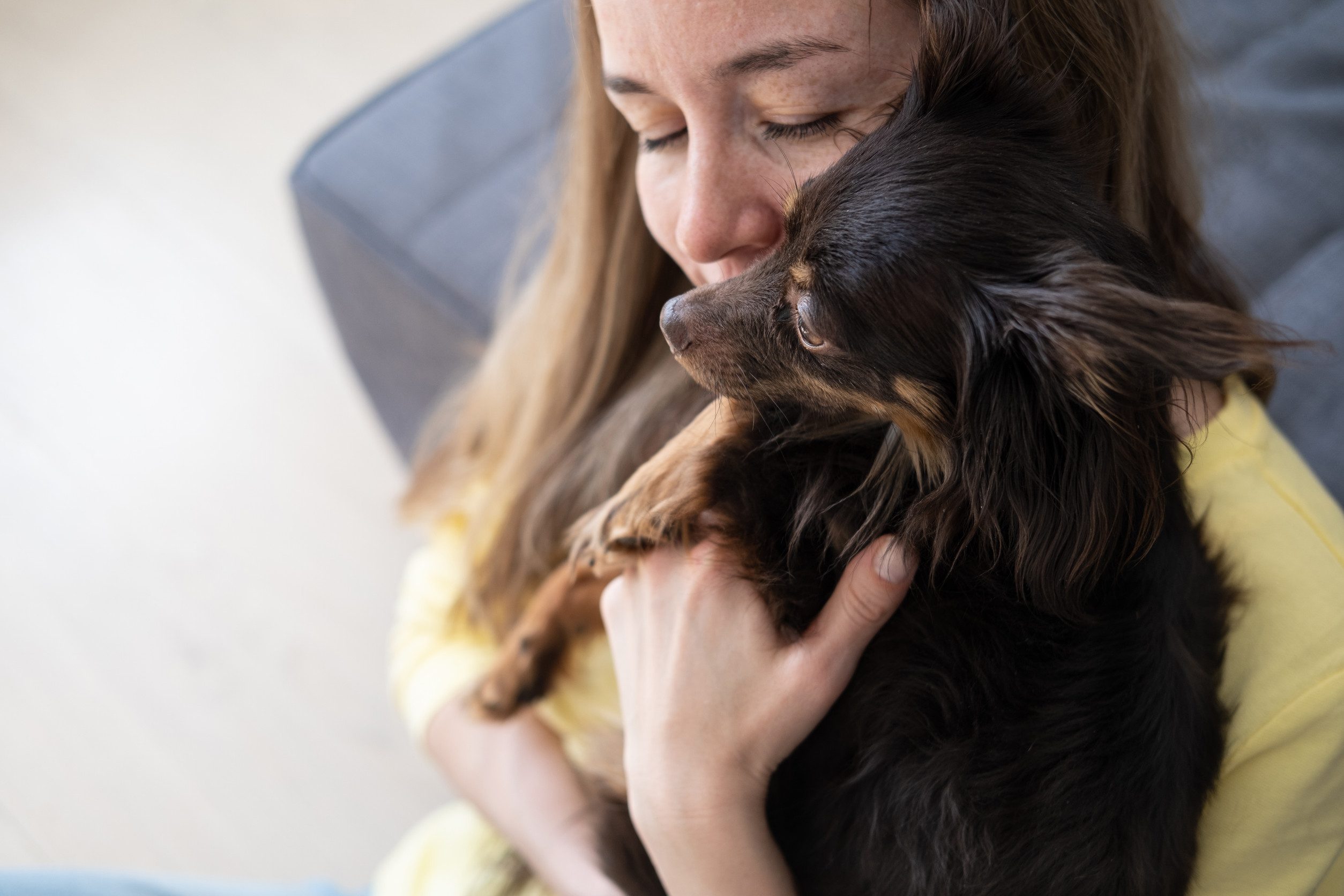 A close-up photo of a woman holding her emotional support animal tightly in Stockton, CA.