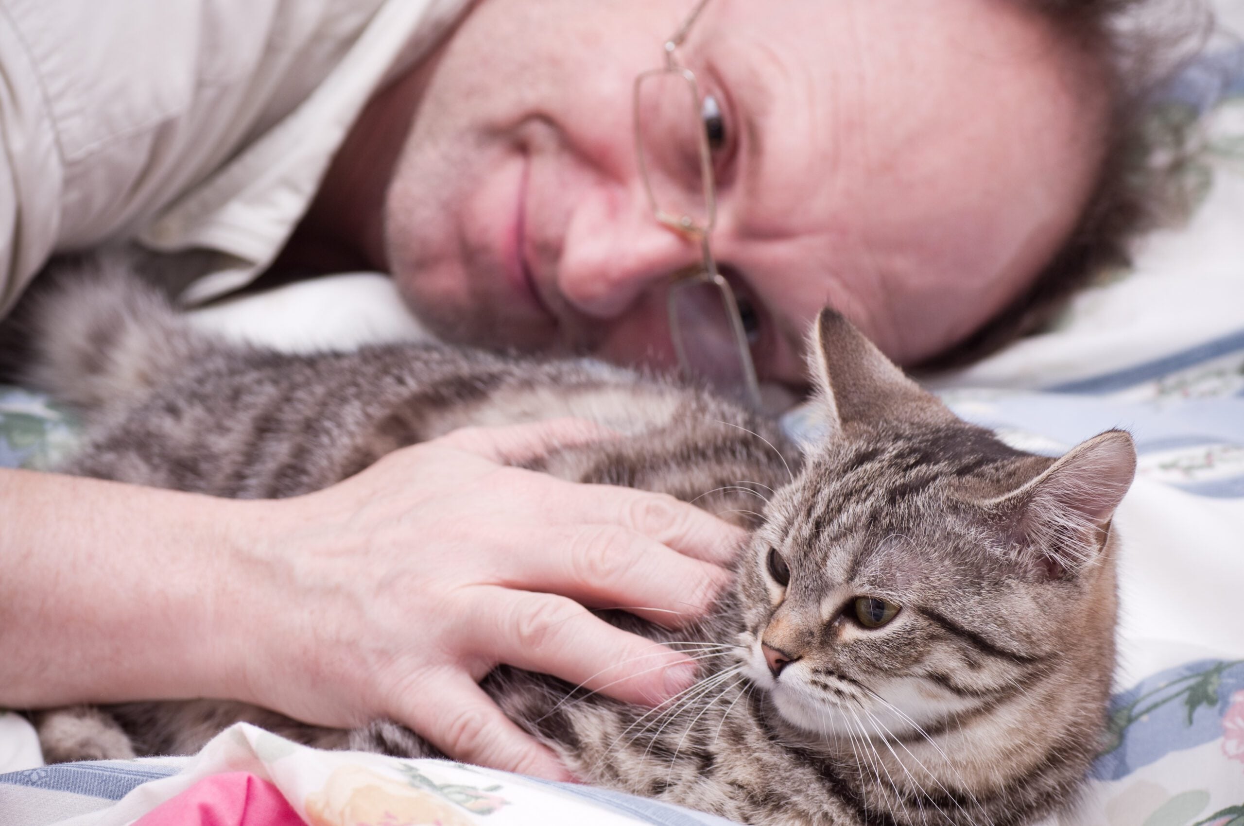 A man in Joliet, IL cuddling his emotional support cat. 
