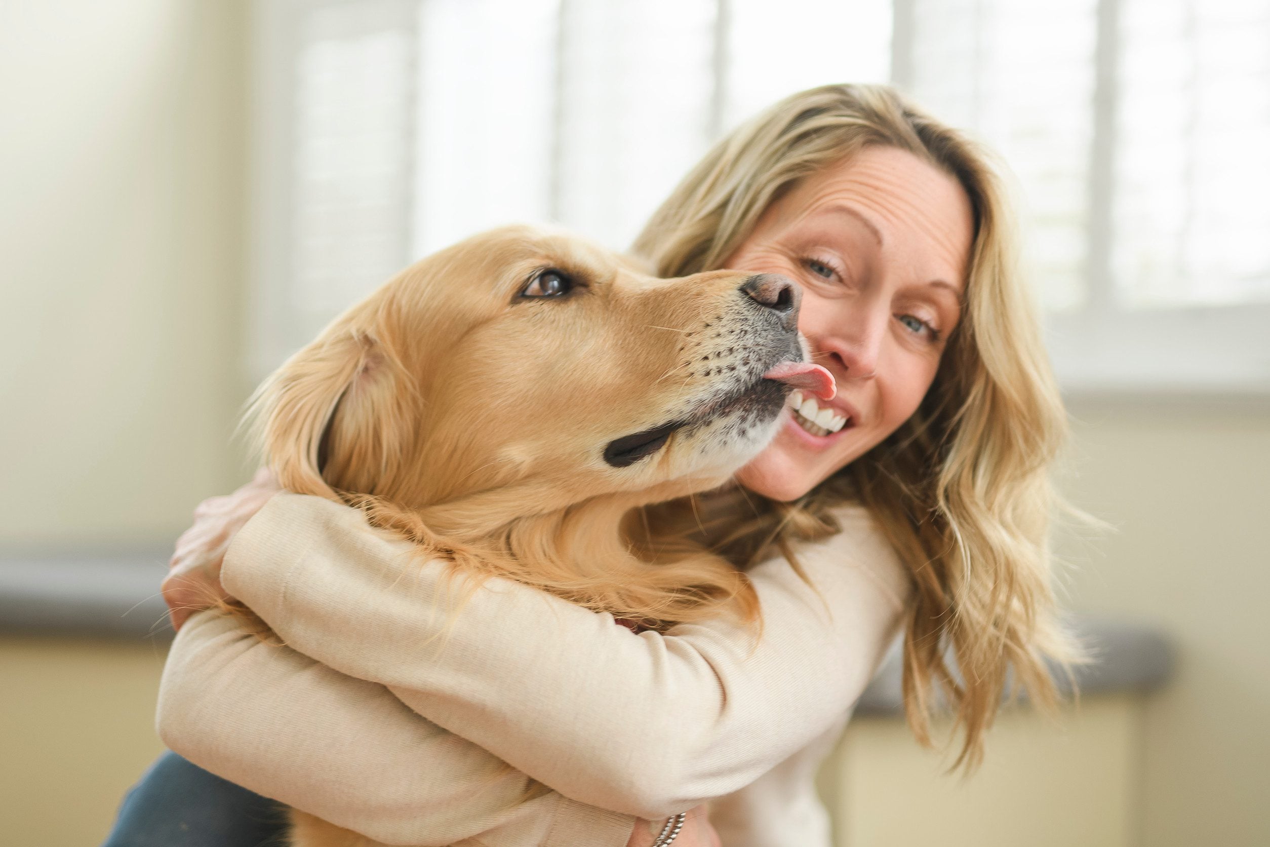 A woman smiling while hugging her emotional support animal in Lewiston, ME.