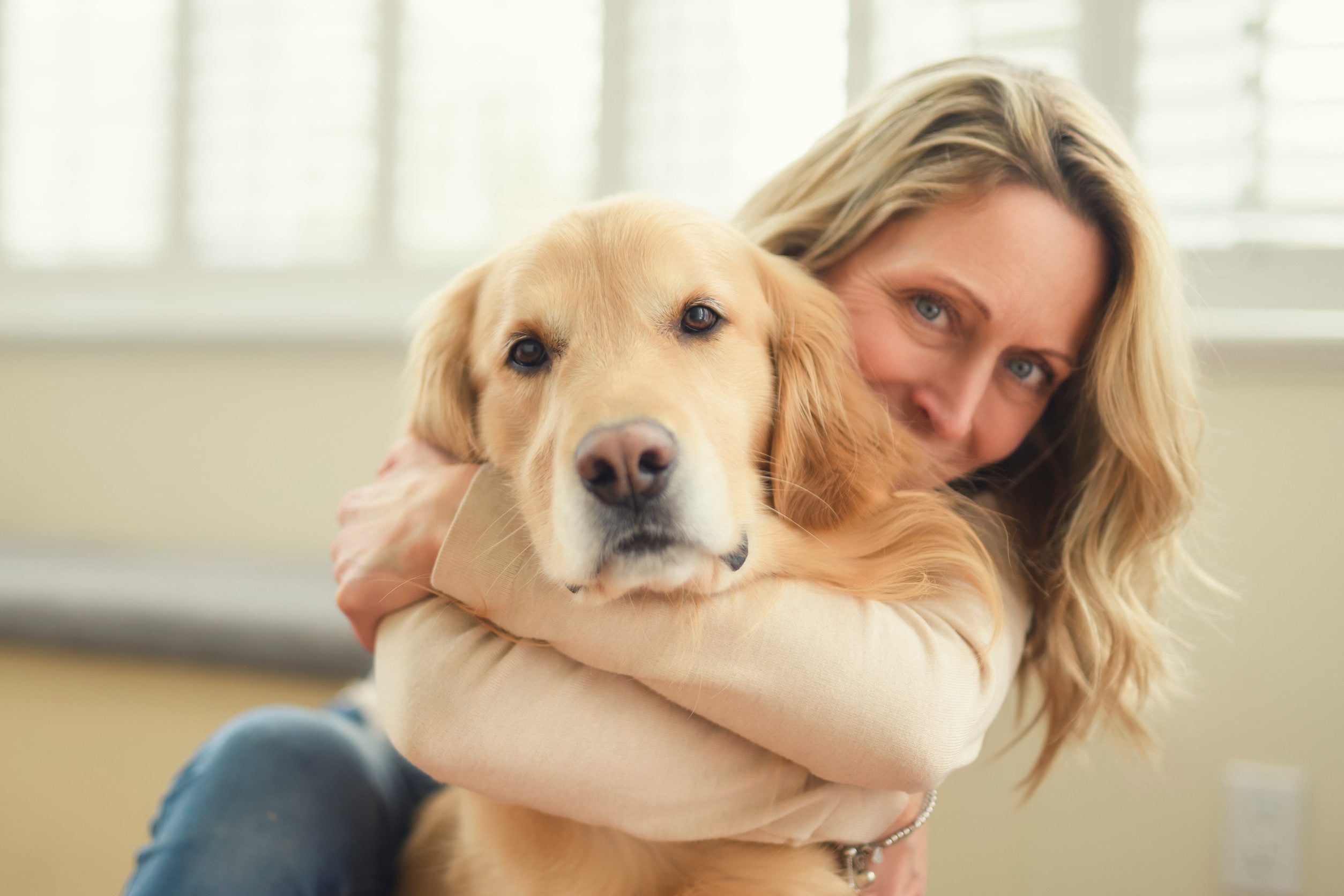 A woman hugging her golden retriever after getting an emotional support animal letter in Columbia.