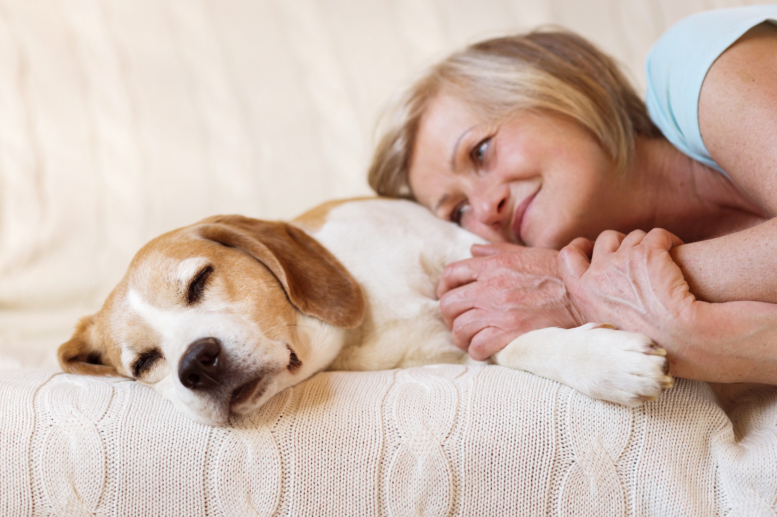 Woman lying with her emotional support animal in Grand Island home.