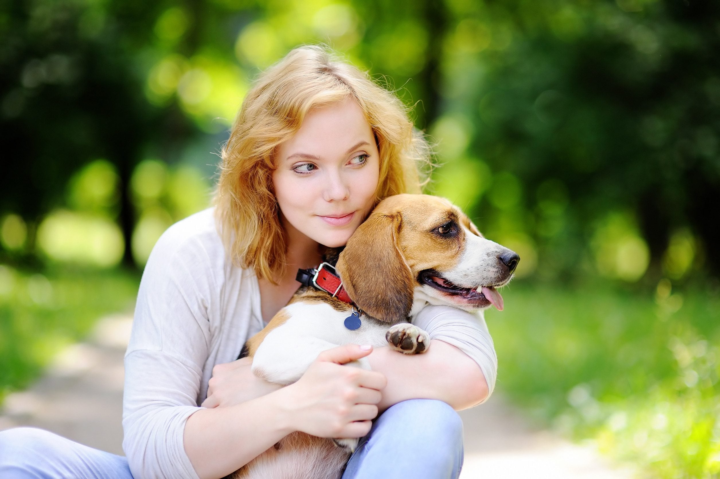 A woman sitting in a park with her emotional support animal in Newark, DE.
