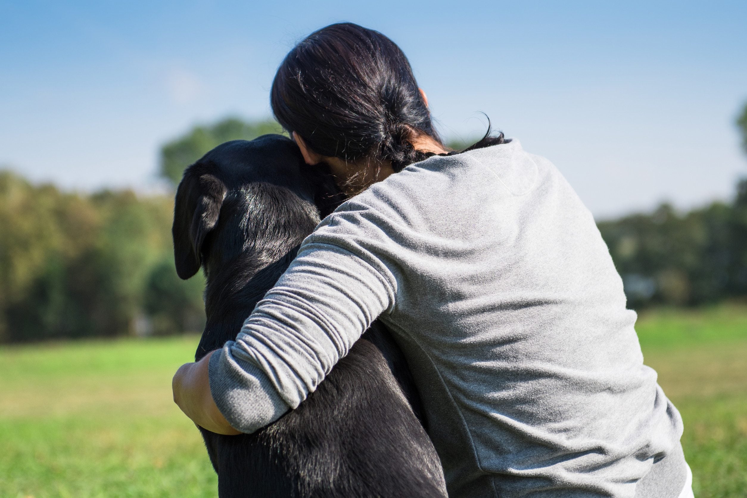A woman hugging her ESA at a dog park in Detroit.