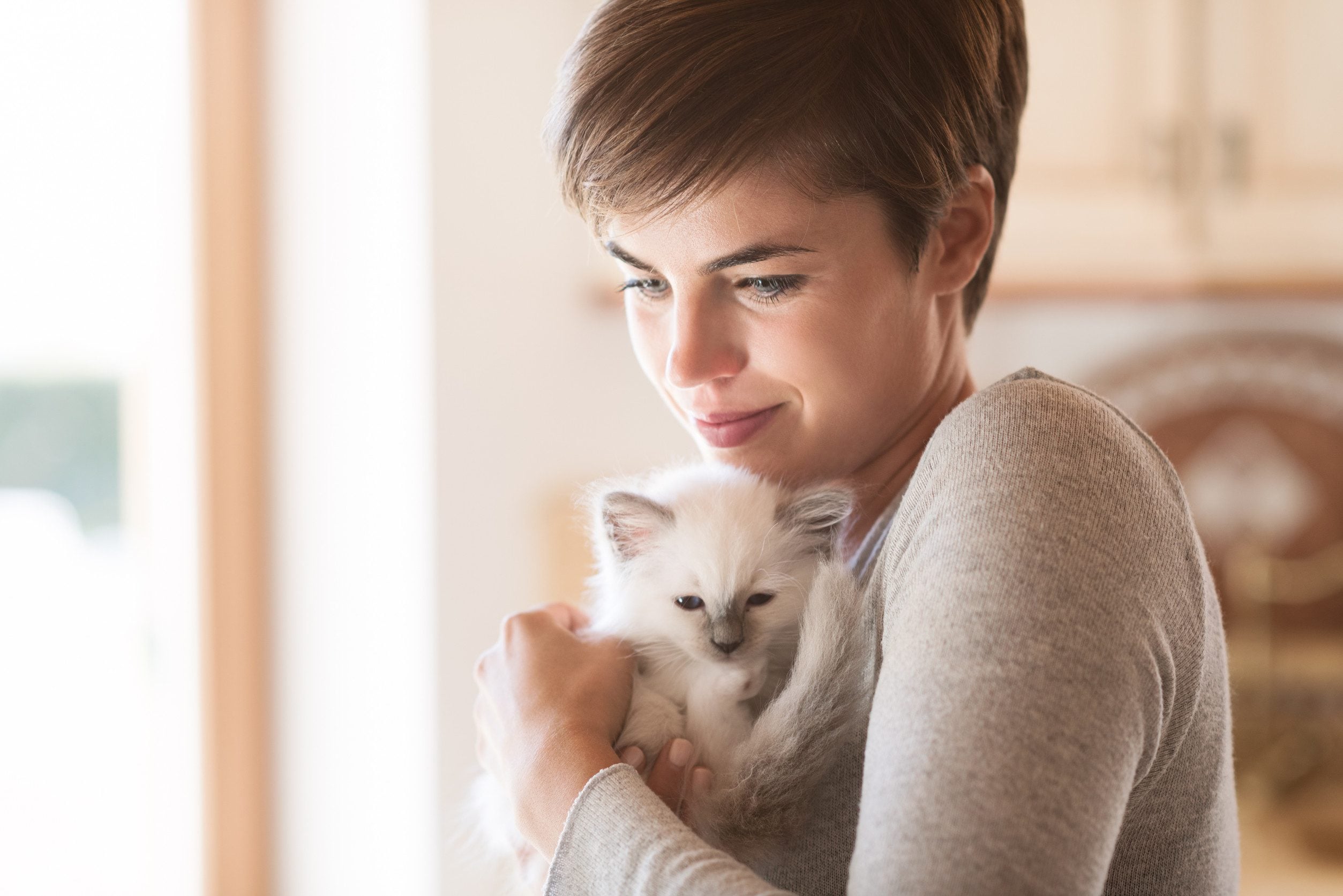 A woman with short hair holding her emotional support animal in Bloomington, MN.