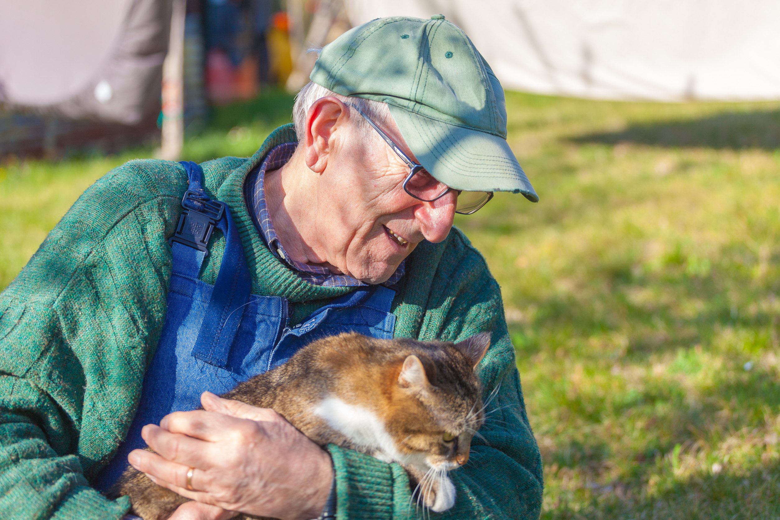 An older man in Broken Arrow, OK, hugging his emotional support animal (ESA) cat.