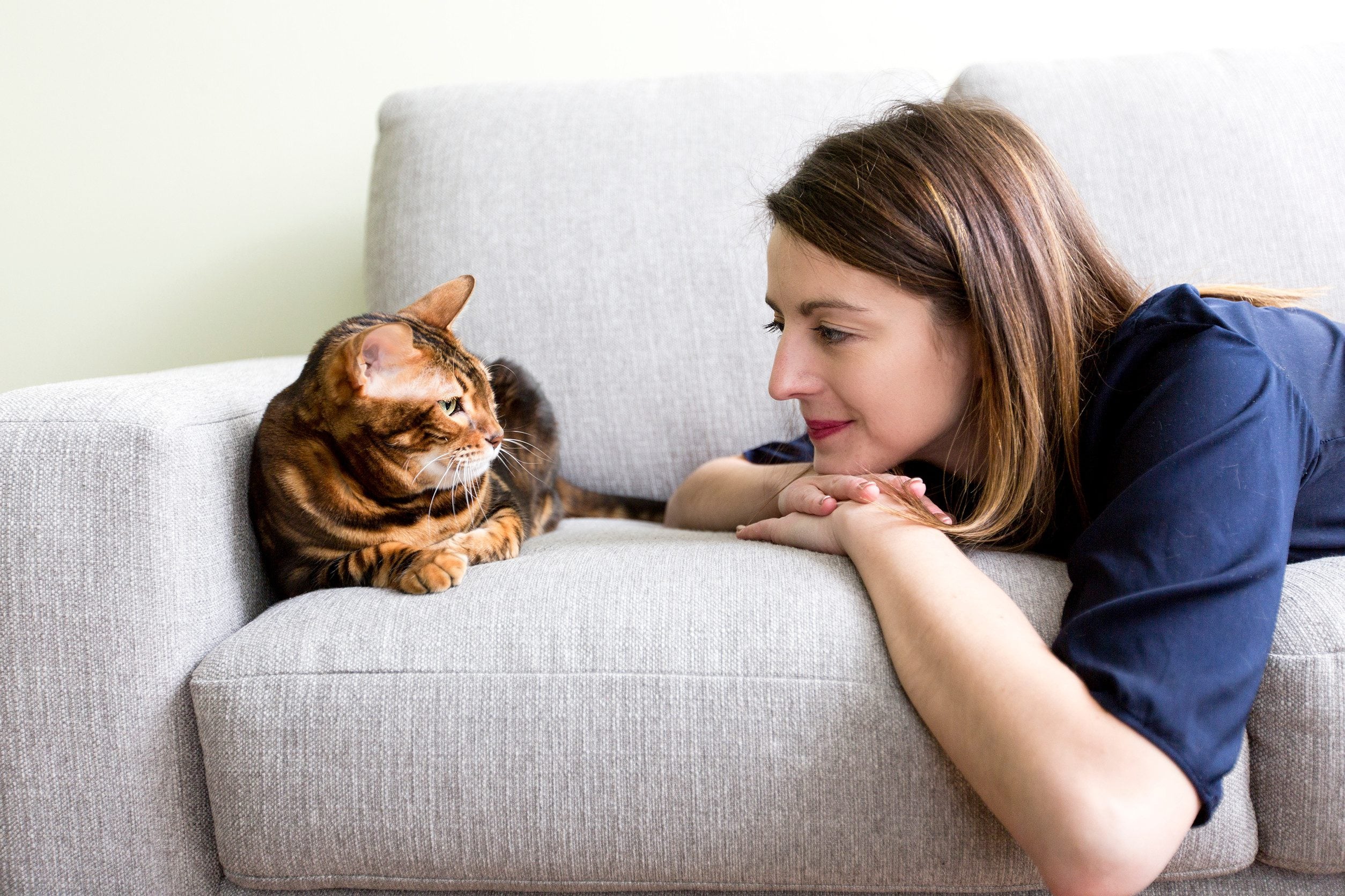 A woman on a couch smiling warmly at her emotional support animal in Cranston, RI.