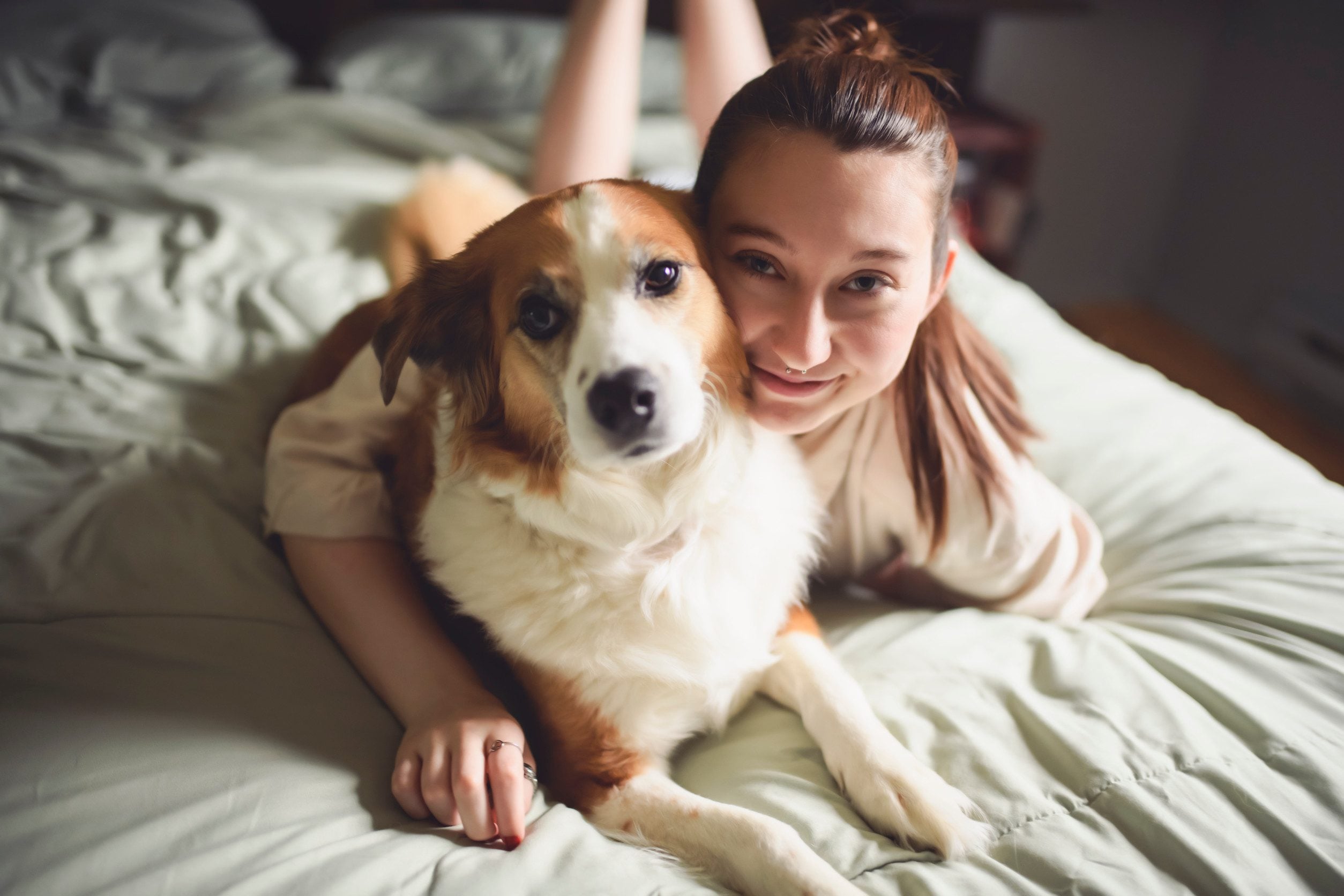 A girl lying in bed with her emotional support dog in Columbia.