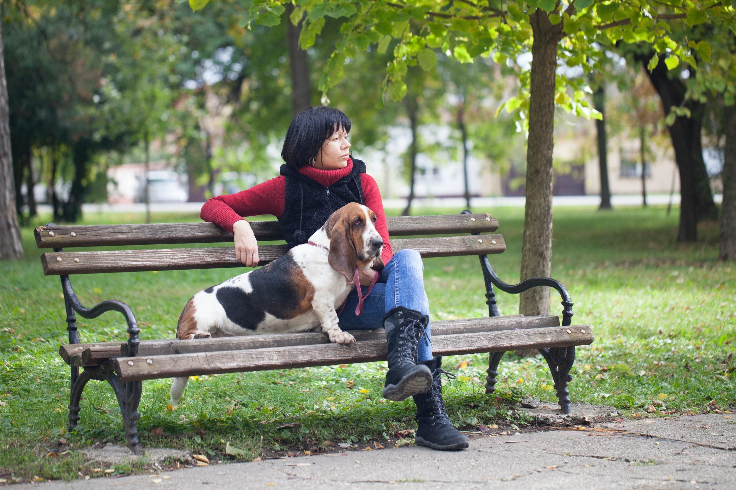 A woman sitting on a bench with her ESA in a park in Rochester, NY.