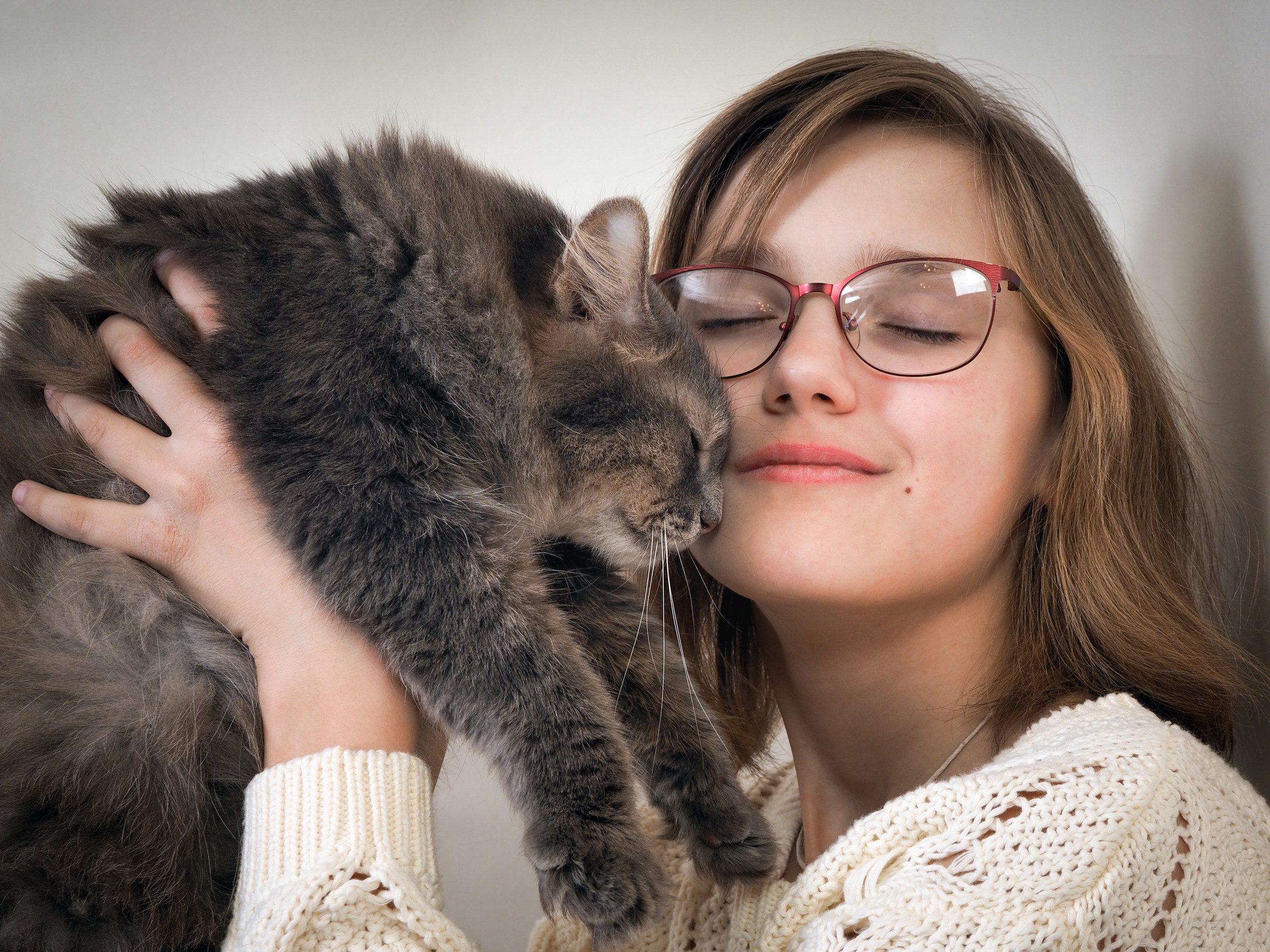 A girl in glasses holding her gray emotional support animal in Albuquerque, NM.