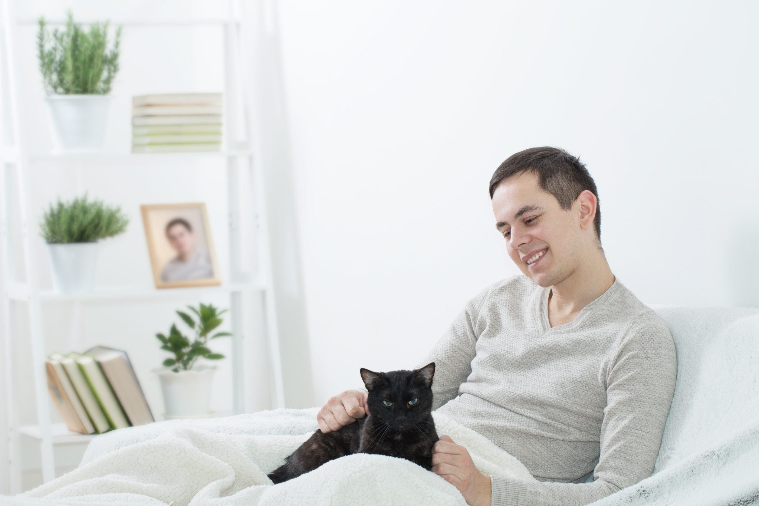 A man sitting under a blanket with his emotional support animal in Durham, NC.