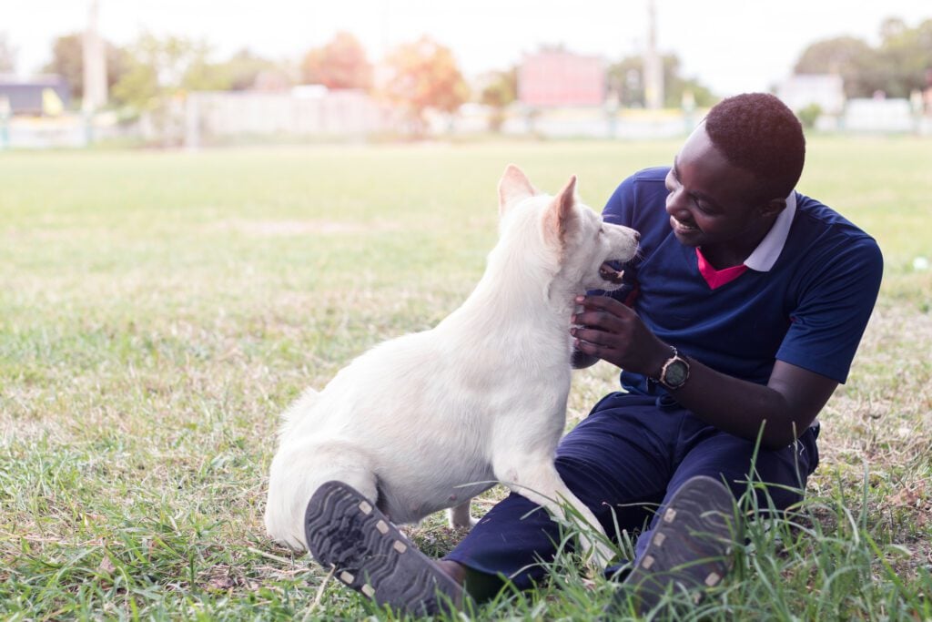 A man plays with his dog after reading up on the best emotional support dogs.
