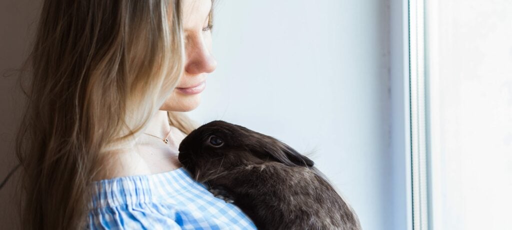 A woman holding an emotional support bunny, at peace after learning when can a landlord legally reject an ESA in Florida.