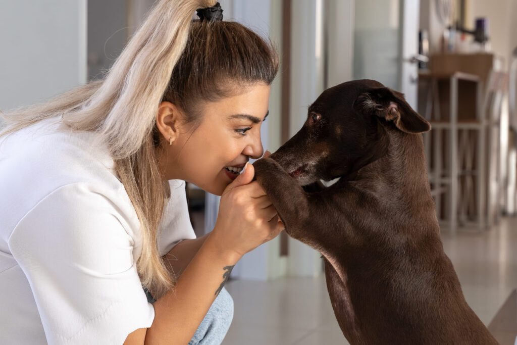 A young woman playing with her emotional support dog at home, wondering when can a landlord legally reject an ESA in Ohio.